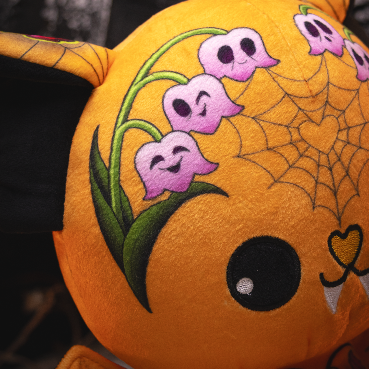 Plush toy with Halloween design featuring ghosts, spider webs, and a smiling face.