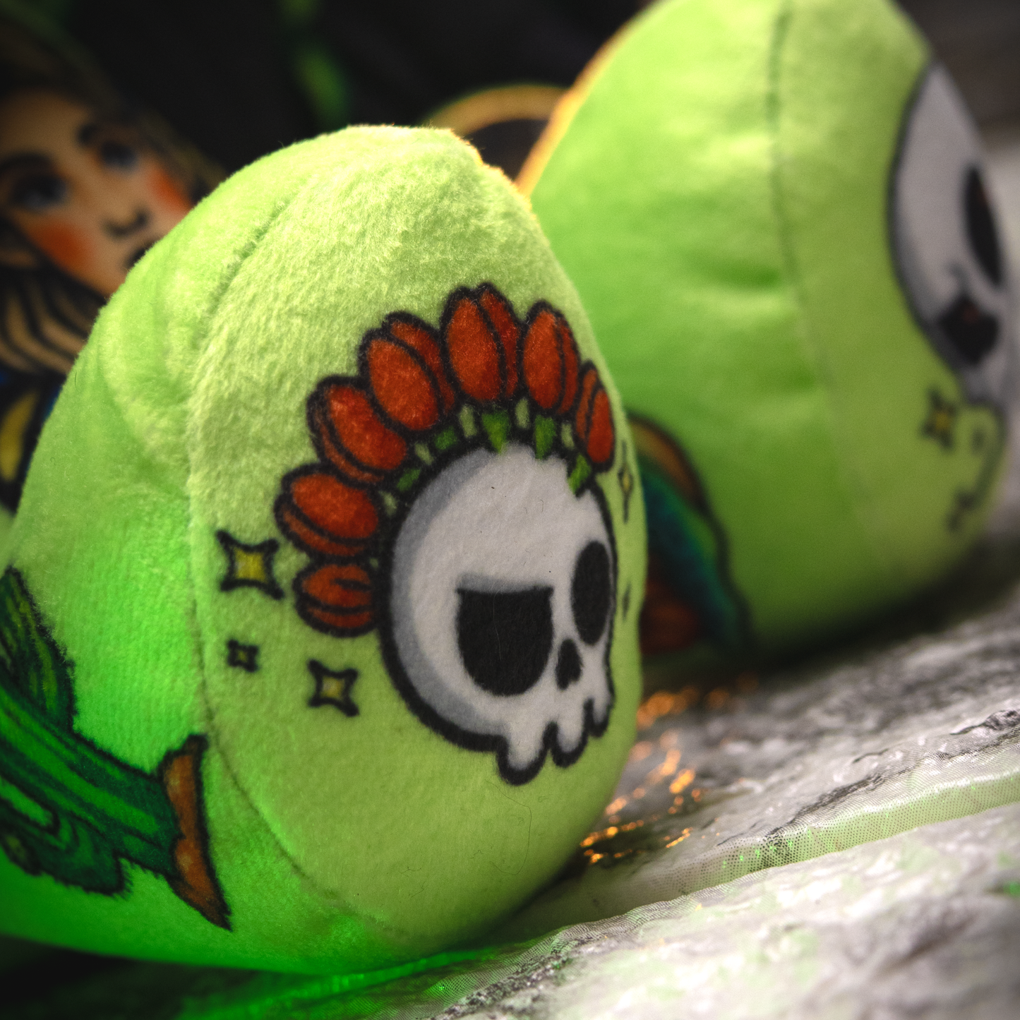 Green plush toy with skull design on a textured surface